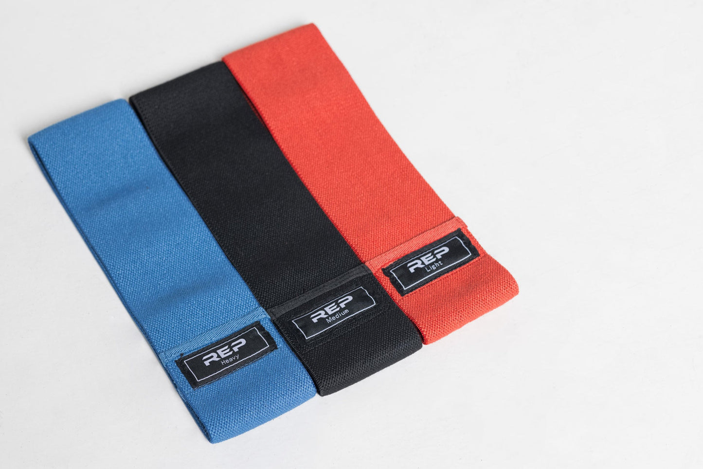Full set of REP circle hip bands: light red, medium black, and heavy blue.